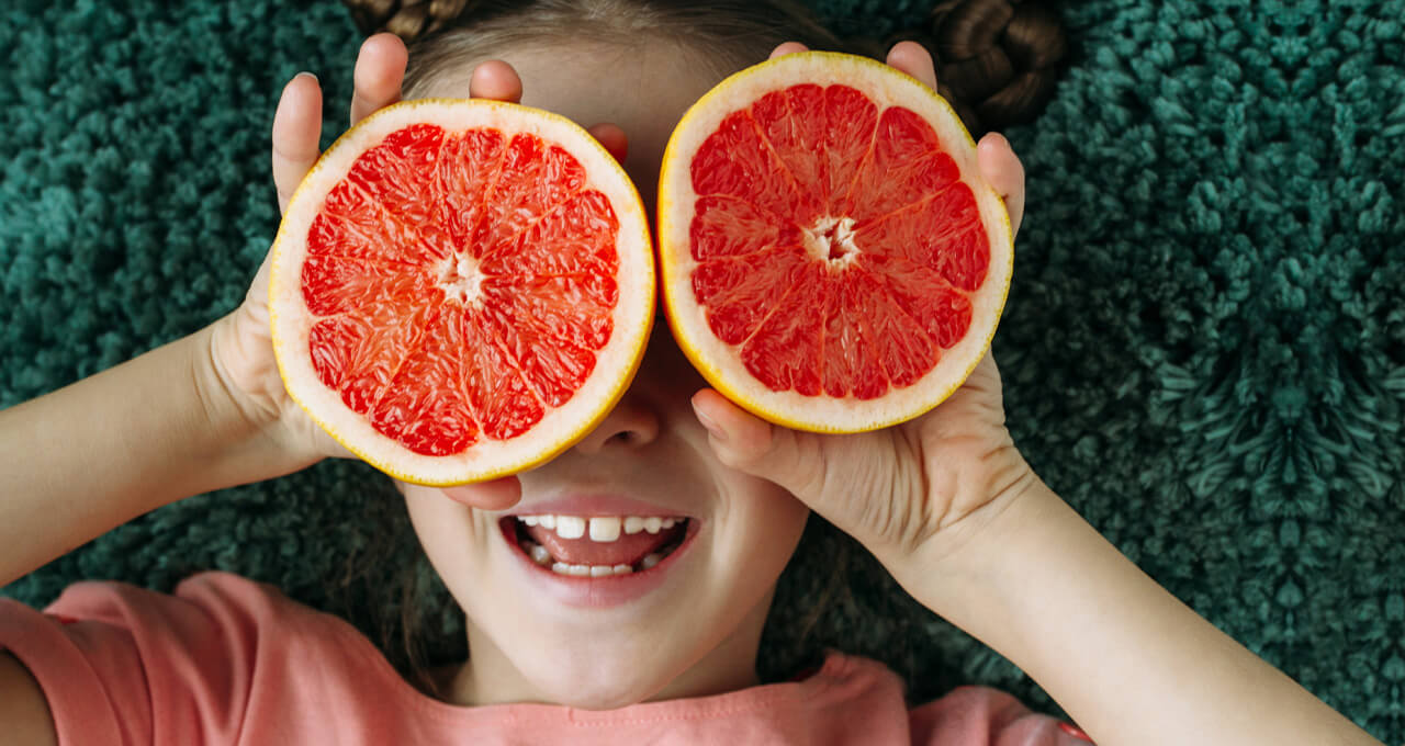 Kind mit Grapefruit