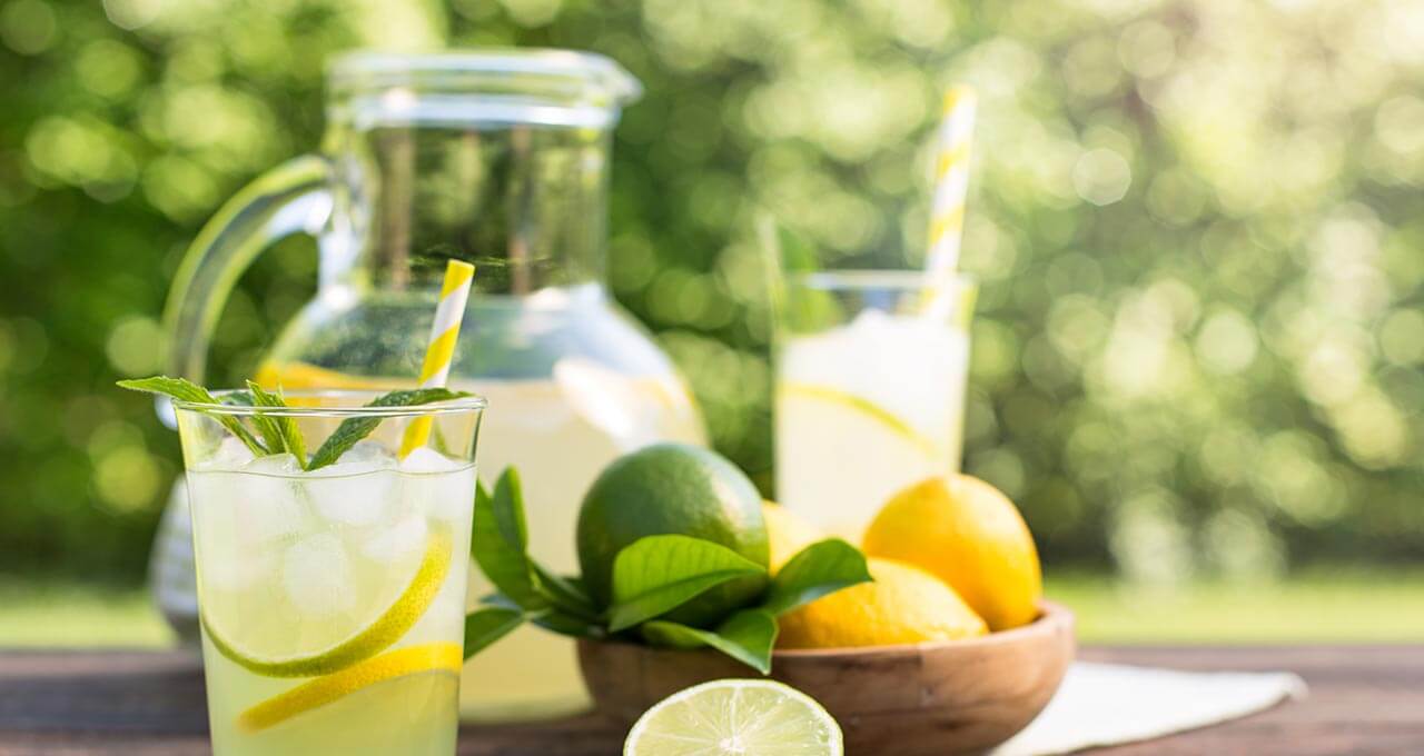 Limonade ohne Zucker im Glas mit Zitronen und Limetten