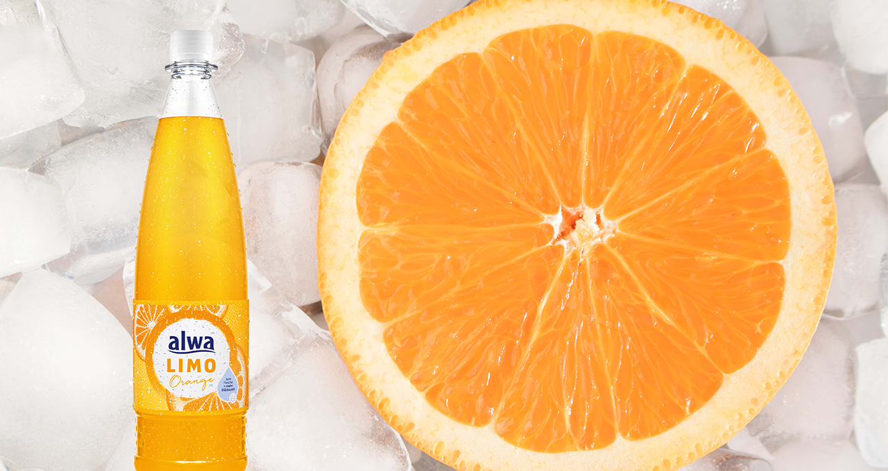 Orangenlimonade in der Flasche und Orangenscheibe im Eis