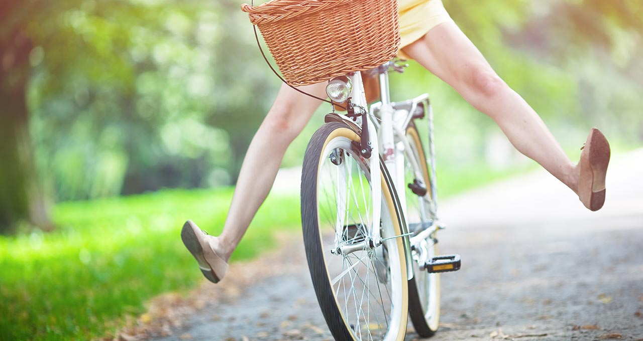 Frau auf Fahrrad mit gelbem Kleid