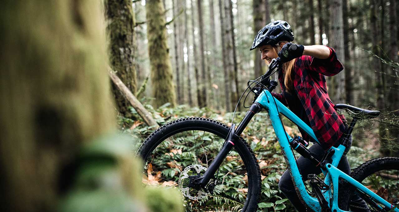 Frau mit Mountainbike im Wald