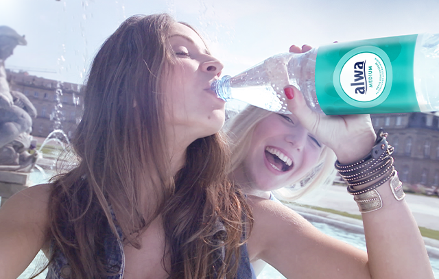 Junge Menschen trinken aus PET-Mehrwegflasche