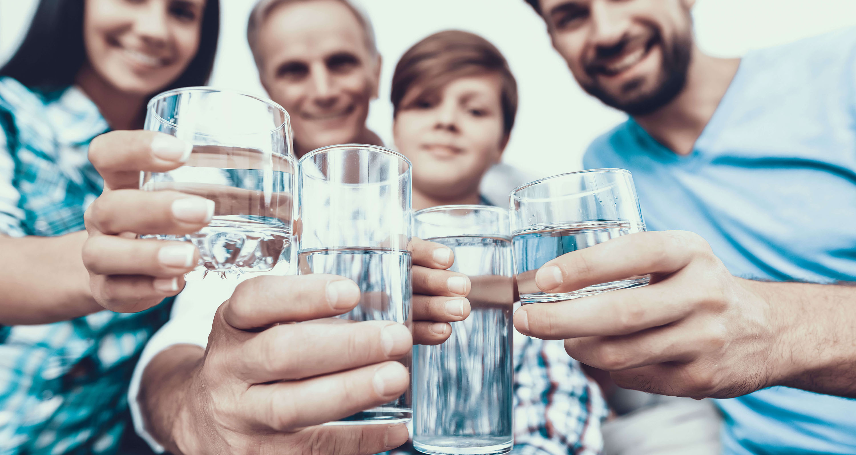Familie mit Mineralwassergläsern in der Hand